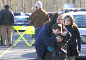 A young boy is comforted outside Sandy Hook Elementary School after a shooting in Newtown